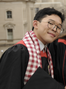 A man wearing a red and white scarf smiling. 